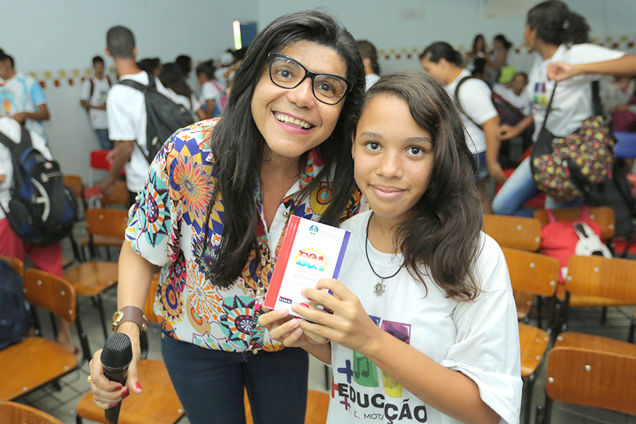 Luzia Rodrigues, coordenadora pedagógica do PCJE, entrega exemplar do ECA para Franciele. Foto: Itawi Albuquerque