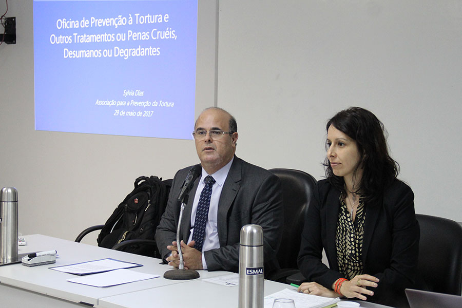 Desembargador Fernando Tourinho fala aos participantes, ao lado da professora Sylvia Dias.