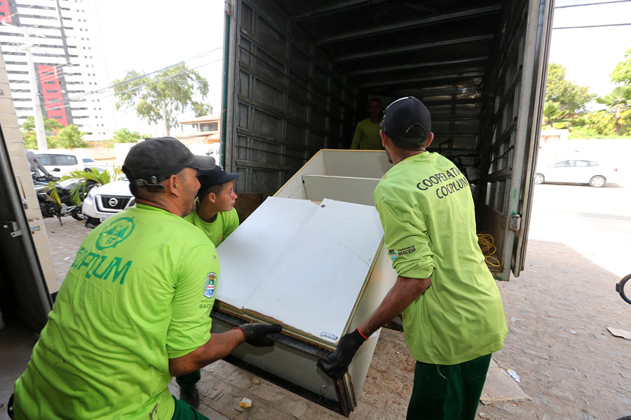 Trabalhadores da Cooplum recolhem material, em 25 de março.