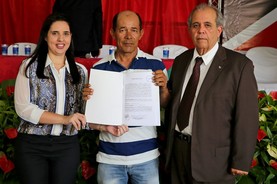 Morador Luzival Santos recebe título das mãos do desembargador Celyrio Adamastor e da prefeita Pauline Pereira.